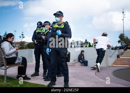 Melbourne, Australie. 25 septembre 2021. 25 septembre 2021, Melbourne, Australie. La police pose une question à un spectateur dans un parc à roulettes, tandis qu'un homme sur une planche à roulettes skate devant un officier, à St Kilda, où des manifestants anti-blocage se sont rassemblés. Credit: Jay Kogler/Alay Live News Credit: Jay Kogler/Alay Live News Banque D'Images