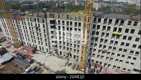 Complexe d'appartements inachevé avec des constructeurs sur le dessus, aérien Banque D'Images