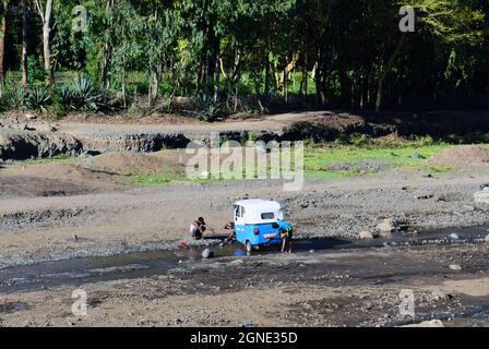 Les Éthiopiens lavant leur TÉLÉVISEUR en pousse-pousse automatique dans un petit ruisseau dans les montagnes éthiopiennes, en Éthiopie. Banque D'Images