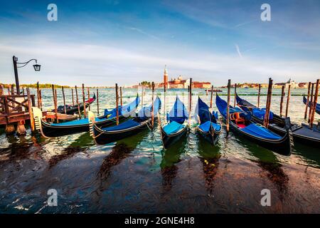 Vue de printemps ensoleillée des gondoles garées à côté de la Riva degli Schiavoni à Venise, Italie, Europe. Magnifique paysage méditerranéen avec église de S. Banque D'Images