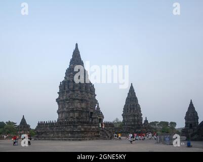 Vue sur l'ancien temple de Prambanan et la foule de touristes à Yogyakarta avec ciel bleu clair coucher de soleil fond. Banque D'Images