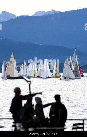 Lindau am Bodensee, Allemagne. 25 septembre 2021. Des dizaines de bateaux partent de Bregenz, sur le lac de Constance, pour la régate « rund UM », tandis que, en premier plan, les gens se tiennent sur le front de mer pour observer le départ. Environ 235 bateaux participent à la régate. Bregenz dans le Vorarlberg autrichien peut être vu en arrière-plan. Credit: Felix Kästle/dpa/Alay Live News Banque D'Images