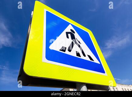 Panneau de rue à traverser pour piétons, vue rapprochée sur fond bleu ciel. Vue en angle Banque D'Images