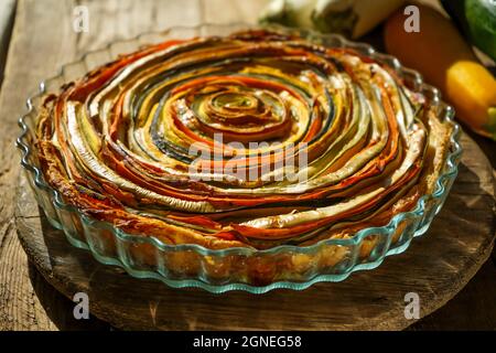 Tarte aux légumes soleil mexicain. Tarte ouverte ronde à base de courgettes, d'aubergines et de carottes. Vue rapprochée du dessus. Aliments sains à base de légumes. Végétarisme. Spirale Banque D'Images