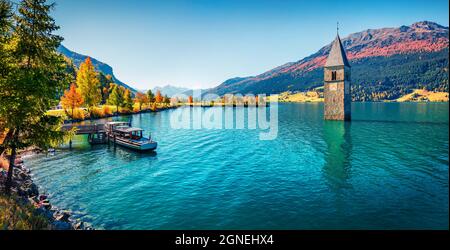 Vue d'automne panoramique sur la Tour de l'église encastrée dans le lac Resia. Matin ensoleillé scène des Alpes italiennes, Tyrol du Sud, Italie, Europe. Concept de voyage de retour Banque D'Images