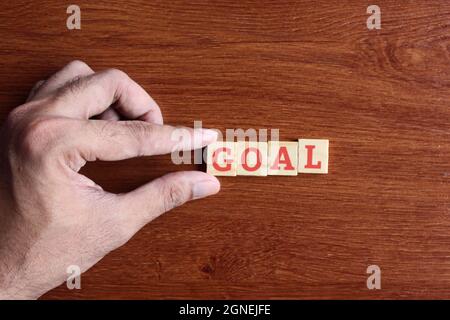 Concept de motivation et d'inspiration. Doigt mettant des cubes en bois avec le but de texte Banque D'Images