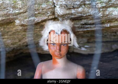 Creepy à la poupée avec la peau animale hat. Partie d'une ancienne grotte et patiné à l'affichage, d'Oribi Gorge Afrique du Sud. Banque D'Images