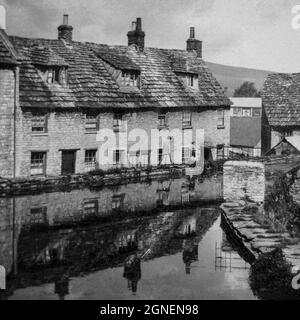 Les chalets en pierre de Purbeck près de l'étang du moulin à Swanage en 1926, avec un panneau de sauce HP ou une publicité en arrière-plan Banque D'Images