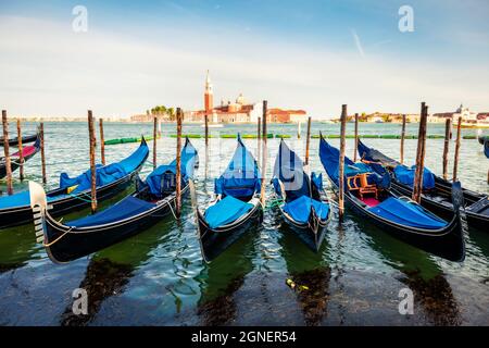 Vue de printemps ensoleillée des gondoles garées à côté de la Riva degli Schiavoni à Venise, Italie, Europe. Magnifique paysage méditerranéen avec église de S. Banque D'Images