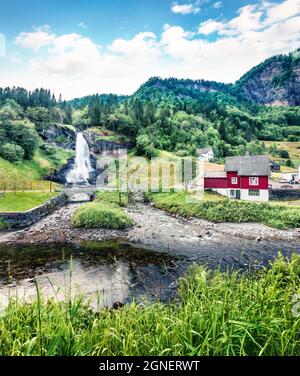 Superbe scène estivale de la cascade Steinsdalsfossen sur la rivière Fosselva. Scène pittoresque du village de Steine, municipalité de Kvam dans le Hord Banque D'Images