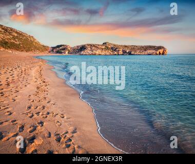 Empreintes de pas dans le sable sur la célèbre plage turque de Patara. Coucher de soleil coloré dans la Turquie, district de Kas, province d'Antalya, Asie. Beauté de la nature co Banque D'Images
