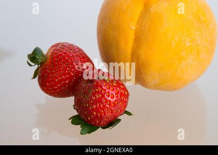 gros plan sur les fraises rouges et la pêche jaune Banque D'Images