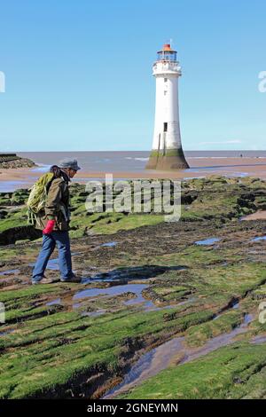 Walker Crossing rochers couverts d'algues devant le phare de New Brighton, Wirral Banque D'Images