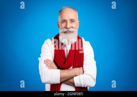 Photo de mignon attrayant âge gentleman porter blanc chandail rouge foulard bras croisé sourire isolé couleur bleu arrière-plan Banque D'Images