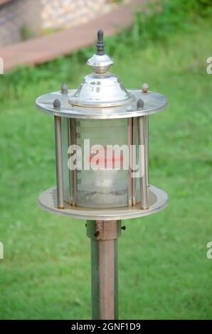 Lampe électrique en verre avec ampoule rouge dans le jardin. Banque D'Images