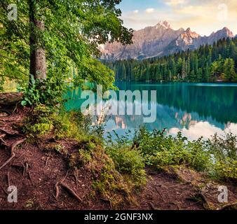 Vue ensoleillée le matin sur le lac de Fusine. Lever de soleil d'été coloré dans les Alpes juliennes avec le pic de Mangart en arrière-plan, province d'Udine, Italie, Europe. Déplacement Banque D'Images