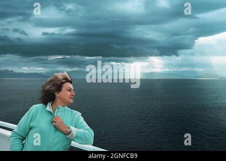 belle femme mûre met son visage au vent. Traversée en ferry sur la mer du Nord, Norvège. Portrait d'une femme active mature. Espace de copie Banque D'Images