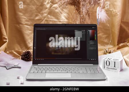 Kiev, Ukraine - septembre 23: Formation à l'édition de photos par Photoshop sur Youtube sur ordinateur portable, coupe rouge et guimauves. Ambiance de travail festive avec guirlandes. 1er décembre. Hiver atmosphère chaleureuse Banque D'Images