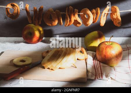 Pommes mûres et séchage et pommes dans la grange. Pommes de récolte et de séchage. Tranches de pomme séchées sur une corde dans une grange. Arrière-plan avec espace pour le texte Banque D'Images