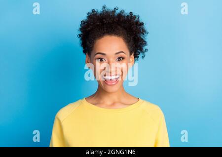 Photo portrait curly femme souriante surjoyeuse heureux dans chemise jaune isolé pastel bleu couleur fond Banque D'Images