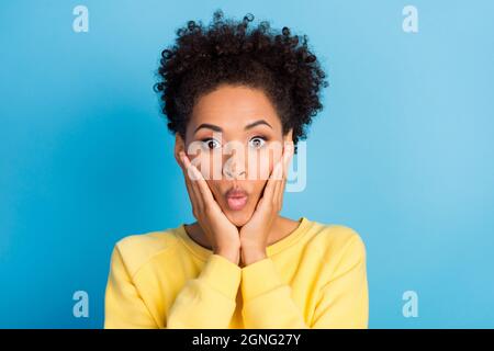 Photo portrait curly femme souriante surprise excitée toucher joues bouted lèvres isolé pastel bleu couleur fond Banque D'Images