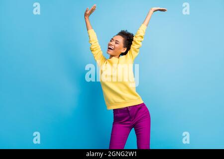 Photo portrait jeune fille souriante dansant surjoyeuse à la fête regardant le copyspace isolé pastel bleu couleur fond Banque D'Images