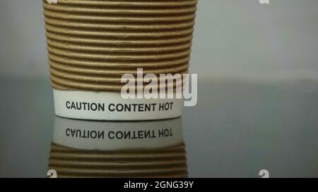 Gobelet à boissons nervuré en papier jetable, petit logo Keep Britain Tidy et mise en garde Table des matières Avertissement de surchauffe. Banque D'Images