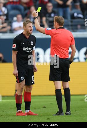 25 septembre 2021, Hessen, Francfort-sur-le-main: Football: Bundesliga, Eintracht Frankfurt - 1. FC Köln, Matchday 6 au Deutsche Bank Park. L'arbitre Martin Petersen (r) montre le carton jaune Martin Hinteregger de Francfort. Photo: Arne Dedert/dpa - NOTE IMPORTANTE: Conformément aux règlements de la DFL Deutsche Fußball Liga et/ou de la DFB Deutscher Fußball-Bund, il est interdit d'utiliser ou d'avoir utilisé des photos prises dans le stade et/ou du match sous forme de séquences et/ou de séries de photos de type vidéo. Banque D'Images