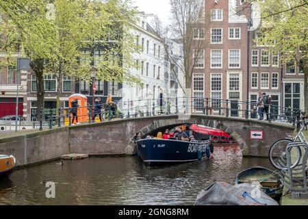 Amsterdam, pays-Bas - avril 2019 : bateau touristique passant sous un pont étroit dans l'un des nombreux canaux d'Amsterdam Banque D'Images