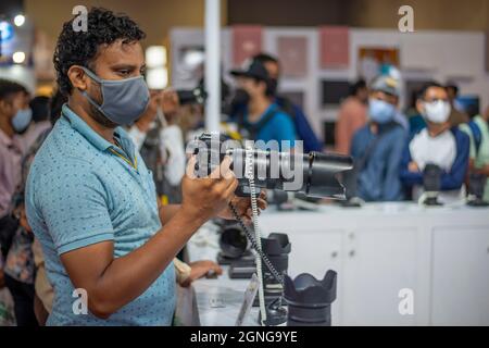 New Delhi, Inde. 25 septembre 2021. Un photographe professionnel vérifie l'objectif de l'appareil photo lors de l'exposition photo Video Asia 2021 qui s'est tenue à Pragati Maidan (le plus grand centre d'exposition) à New Delhi.photo Video Asia est une plate-forme B2B pour l'industrie de la photographie et de la vidéographie en Inde, qui fournit un environnement de réseautage profond aux parties prenantes ou aux hommes d'affaires. Crédit : SOPA Images Limited/Alamy Live News Banque D'Images