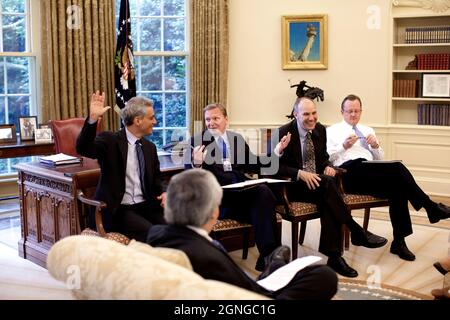 Le chef de cabinet Rahm Emanuel (à gauche) prend la main avec joie lors d'une réunion avec le chef de cabinet adjoint Jim Messina, l'adjoint du président pour les affaires législatives Phil Schiliro, le secrétaire de presse Robert Gibbs et le conseiller principal Pete Rouse (en premier plan) dans le Bureau ovale le 10 juin 2009. (Photo officielle de la Maison Blanche par Pete Souza.) Cette photographie officielle de la Maison Blanche est mise à la disposition des organismes de presse pour publication et/ou pour impression personnelle par le(s) sujet(s) de la photographie. La photographie ne peut être manipulée d'aucune façon ni utilisée dans des documents, des publicités, des produits, o Banque D'Images