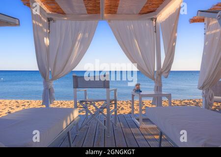 Canapés de plage blancs : chaises longues sur la plage. Tentes de plage de luxe dans un complexe à Apulia, Italie. Banque D'Images