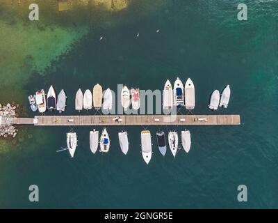 Une vue de dessus des bateaux de pêche qui s'ancre dans la marina à côté de la jetée en bois Banque D'Images