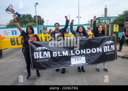 Londres, Royaume-Uni. 25 septembre 2021. Les marcheurs détiennent une bannière de Black Lives Matter et élèvent des poings devant les portes de l'incinérateur d'Edmonton pour protester contre les plans de la North London Waste Authority pour construire un incinérateur plus important, d'un coût de 1,2 milliards de livres sterling sur le site, dans l'une des zones les plus défavorisées et les plus multiculturelles de Londres. augmentation de la pollution de l'air qui enfreint déjà les limites légales. Elle mettrait 700,000 tonnes de CO2 dans l'atmosphère chaque année, ce qui est incompatible avec les objectifs nets de zéro. L'incinération décourage le recyclage et environ la moitié des déchets actuellement brûlés pourraient être recyclés. Peter Marshall/Alay Live News Banque D'Images