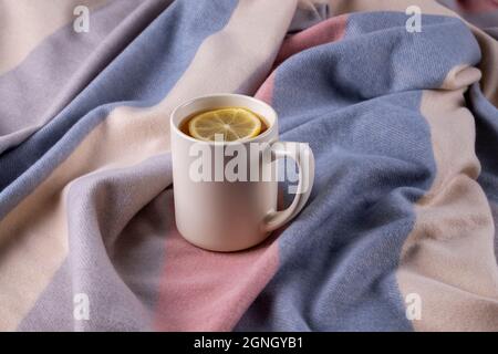 Foulard doux aux couleurs pastel et mug en céramique avec thé chaud Banque D'Images