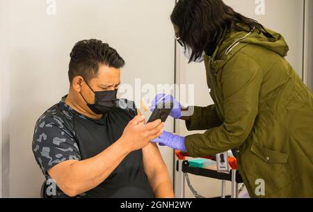 Toronto, Canada. 25 septembre 2021. Un homme portant un masque prend un selfie alors qu'il reçoit une dose du vaccin COVID-19 dans une station de métro de Toronto, Canada, le 25 septembre 2021. Les cas cumulatifs de COVID-19 au Canada ont dépassé 1,600,000 le samedi après-midi, avec un total de 1,600,354 cas, dont 27,636 décès, selon CTV. Credit: Zou Zheng/Xinhua/Alamy Live News Banque D'Images