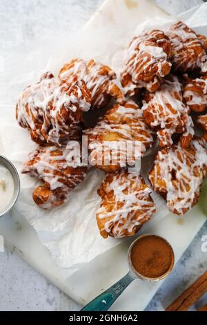 Beignets aux pommes faits maison, arroser de glaçure blanche, mise au point sélective Banque D'Images