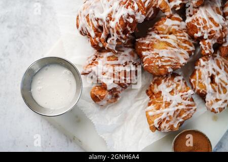 Beignets aux pommes faits maison, arroser de glaçure blanche, mise au point sélective Banque D'Images