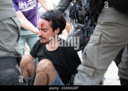 Des policiers israéliens et des soldats de la patrouille frontalière des FDI ont arrêté des manifestants israéliens pour avoir agité des drapeaux palestiniens lors de la manifestation de solidarité hebdomadaire à Sheikh Jarrah. Bien que le ministre de la sécurité intérieure ait ordonné à la police d'arrêter la confiscation violente il y a un mois, les ordonnances ne sont pas appliquées sur le terrain. Le manifestant a été traité dans une salle d'urgence en raison d'une blessure à la tête. Jérusalem, Israël. 24 septembre 2021. Credit: Matan Golan/Alay Live News Banque D'Images