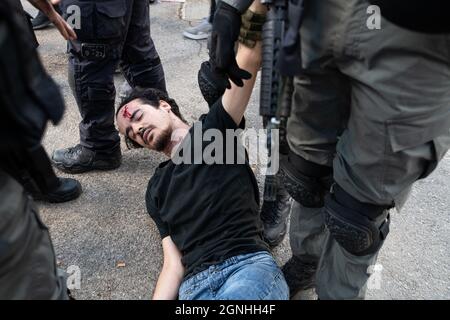 Des policiers israéliens et des soldats de la patrouille frontalière des FDI ont arrêté des manifestants israéliens pour avoir agité des drapeaux palestiniens lors de la manifestation de solidarité hebdomadaire à Sheikh Jarrah. Bien que le ministre de la sécurité intérieure ait ordonné à la police d'arrêter la confiscation violente il y a un mois, les ordonnances ne sont pas appliquées sur le terrain. Le manifestant a été traité dans une salle d'urgence en raison d'une blessure à la tête. Jérusalem, Israël. 24 septembre 2021. Credit: Matan Golan/Alay Live News Banque D'Images