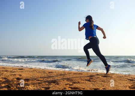 femme qui court sur la plage le matin Banque D'Images