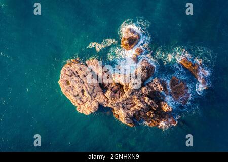 Vue de haut en bas des roches volcaniques dans la mer Méditerranée. Vue depuis un drone volant sur la rive de la péninsule de Milazzo. Magnifique scène de printemps de la Sicile, Ital Banque D'Images