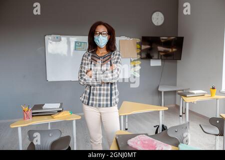 Afro-américaine femme aux bras croisés portant un masque de protection Banque D'Images
