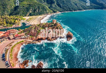 Vue depuis un drone volant. Paysage urbain ensoleillé le matin de la ville de Porto avec la tour de la Genoise de Porto Ota. Vue aérienne du printemps de l'île de Corse, France, Europe. Banque D'Images