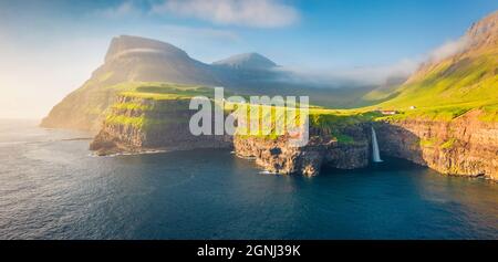 Vue depuis un drone volant. Scène panoramique matinale de la cascade de Mulafossur. Vue estivale ensoleillée de l'île de Vagar, îles Féroé, Danemark, Europe. Beauté de Banque D'Images