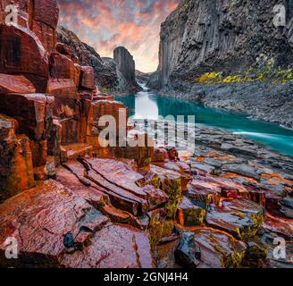 Falaise de rochers rouges dans le canyon profond de la rivière de montagne. Fantastique lever de soleil en automne sur Studlagil Canyon. Impressionnant paysage du matin de Jokulsa À la rivière Bru, moi Banque D'Images