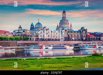 Belle vue sur l'Académie des Beaux-Arts et l'église baroque de la cathédrale Frauenkirche. Coucher de soleil coloré sur l'Elbe. Magnifique paysage urbain de Dresd Banque D'Images