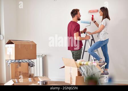 Couple souriant avec la peinture de réparation de l'appartement ou la maison Banque D'Images