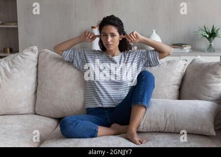 Jeune femme hispanique malheureuse se sentant stressée de trop de bruit. Banque D'Images