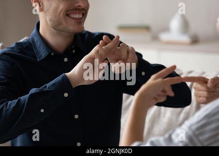 Gros plan image rognée sourire jeune couple en utilisant le langage des signes. Banque D'Images